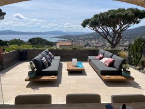 a patio with two couches and a view of a city at Villa les Cades in Sainte-Maxime
