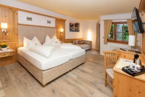 a hotel room with a large bed and a desk at Hotel Zimmerbräu in St. Wolfgang