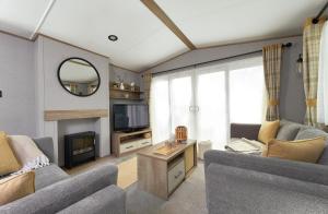 a living room with a couch and a tv at Ullswater Holiday Park - Static 5 in Penrith