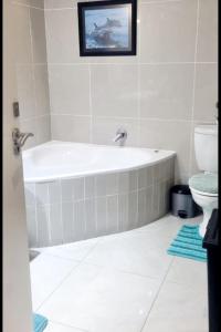 a bathroom with a bath tub and a toilet at Indigo Bay 29 in Margate