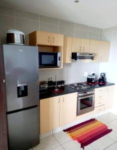 a kitchen with a stainless steel refrigerator and wooden cabinets at Indigo Bay 29 in Margate