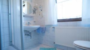 La salle de bains blanche est pourvue d'un lavabo et de toilettes. dans l'établissement Gästehaus Nocker, à Seefeld in Tirol