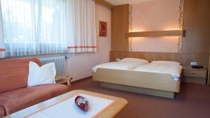 um pequeno quarto com uma cama e um sofá em Gästehaus Nocker em Seefeld no Tirol