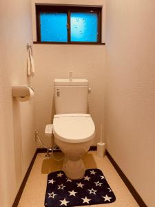 a bathroom with a toilet with an american flag rug at Urasa Cottage @ Snow Countryside in Minami Uonuma