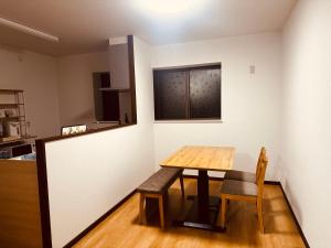 a table and chairs in a room with a kitchen at Urasa Cottage @ Snow Countryside in Minami Uonuma