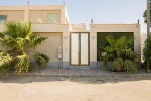 a house with palm trees in front of it at شاليه رويال الخبر - Royal Resort AL Khobar in Al Khobar