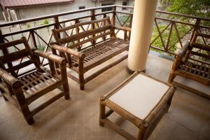 a balcony with two wooden chairs and a pole at The Rubicon Cozy Studio Room 2 in Accra