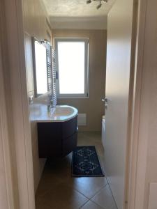 bagno con lavandino, vasca e finestra di Appartamento Solemare a San Vito