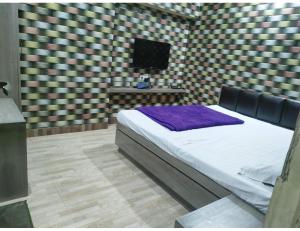 een slaapkamer met een bed en een tafel met een lamp bij Hotel prince palace & restaurant , Ajmer in Ajmer