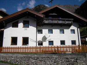 a white house with a wooden fence in front of it at Prantl Roswitha in Sölden