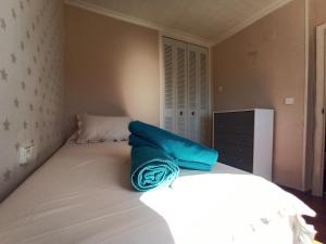 Un dormitorio con una cama blanca con toallas azules. en Casa Alkabir Campello, en El Campello