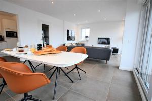 ein Esszimmer und ein Wohnzimmer mit einem weißen Tisch und Stühlen in der Unterkunft Villa Lindholm- Strandnähe -Balkon-im Zentrum von Binz 5 in Binz