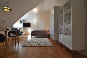 sala de estar con sofá, cama y escritorio en Appartement Crows Nest en Ankum