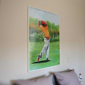 una pintura de un golfista colgando de una pared en Appartement Crows Nest en Ankum