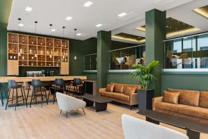 un vestíbulo con bar, mesas y sillas en Azur Hotel Volos, en Volos