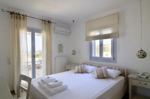 a bedroom with a bed with towels on it at Villa St' Astra in Koufonisia +37 photos