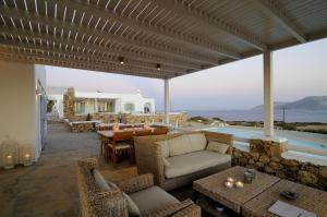 eine Terrasse mit einem Sofa, Stühlen und einem Tisch in der Unterkunft Villa St' Astra in Koufonisia