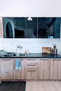una cucina con armadi in legno e lavandino di Getaway to Relax & Play at Meraki ad Agios Stefanos