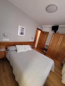 a bedroom with a bed with two pillows on it at Hostal San Felix in Gijón