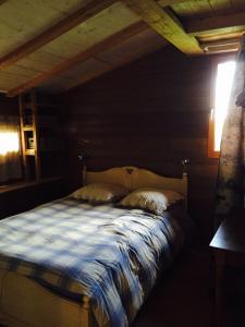 ein Bett mit einer blauen und weißen Decke in einem Zimmer in der Unterkunft Gîte Les Cigognes in Orchamps-Vennes