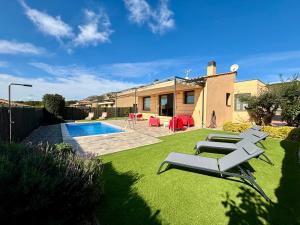 podwórko z krzesłami, basen i dom w obiekcie Villas Medes Mar - Plus Costa Brava w mieście L'Estartit
