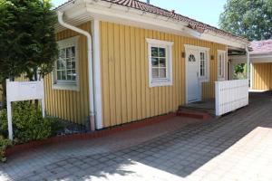 Casa amarilla con puerta blanca y porche en Ferienwohnungen Polchow - direkt am Wasser, en Polchow