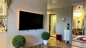 ein Wohnzimmer mit einem Flachbild-TV an der Wand in der Unterkunft Last Floor Apartments in Narva-Jõesuu