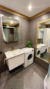 ein Badezimmer mit einer Waschmaschine und einem Waschbecken in der Unterkunft Last Floor Apartments in Narva-Jõesuu