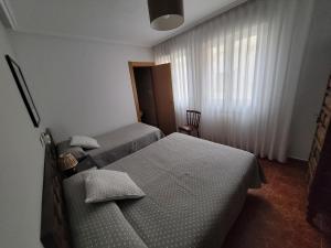 a bedroom with two twin beds and a window at Hostal San Felix in Gijón