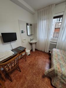 Habitación con cama, lavabo y escritorio. en Hostal San Felix, en Gijón