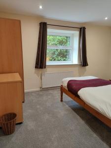 um quarto com uma cama e uma janela em Holiday Cottage 4 em Penrith