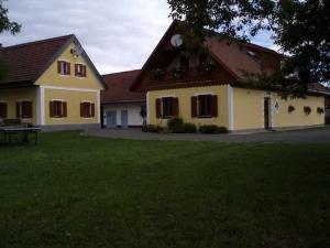 una grande casa gialla con un prato di Ermi Pracher a Groß Sankt Florian