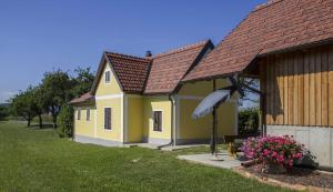 una piccola casa gialla con tetto marrone di Ermi Pracher 