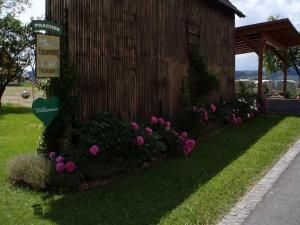 un cartello sul lato di un edificio con fiori rosa di Ermi Pracher 