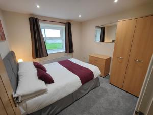 a small bedroom with a bed and a window at Holiday Cottage 4 in Penrith