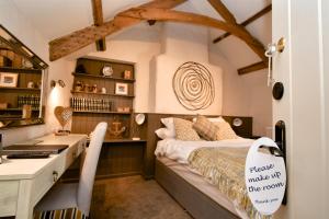 a small bedroom with a bed and a desk and a desk at Carew Inn in Tenby