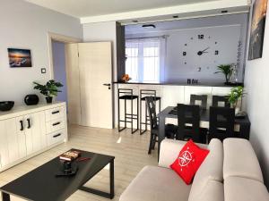 a living room with a couch and a table and a kitchen at Apartament w Helu in Hel