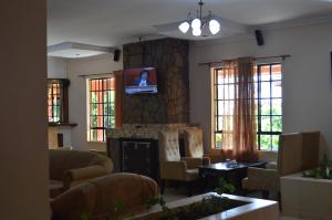 sala de estar con chimenea y TV en la pared en jirime hotel &resort, en Marsabit