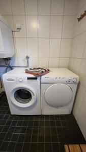 uma máquina de lavar e secar roupa num pequeno quarto em Guesthouse with Sauna em Lahti