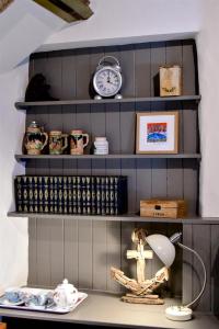 a shelf with a clock and other items on it at Carew Inn in Tenby