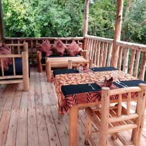 a porch with a table and chairs on a deck at Murchison Giraffe Camp in Murchison Falls National Park
