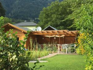 een huis met een tafel en stoelen in een tuin bij Haus Wallner in Dellach im Drautal