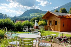 un tavolo e sedie di fronte a una cabina di Haus Wallner a Dellach im Drautal