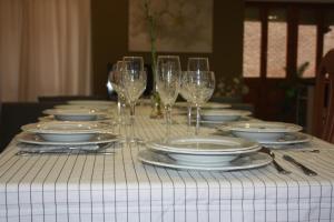 a table with plates and wine glasses on it at Apartamento Turístico Cigüeña de Alfaro in Alfaro