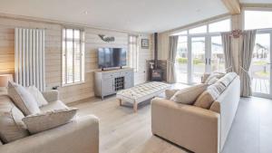 a living room with two couches and a television at Stunning Lodge at Runswick Bay - Dog Friendly in Runswick