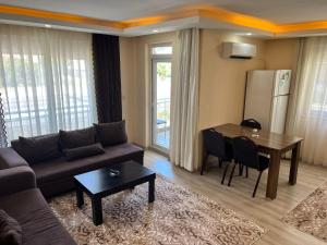 een woonkamer met een bank en een tafel bij Pusula Apart Otel in Antalya