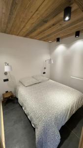 ein Schlafzimmer mit einem Bett und einer Holzdecke in der Unterkunft Maisonnette à Courchevel. in Courchevel