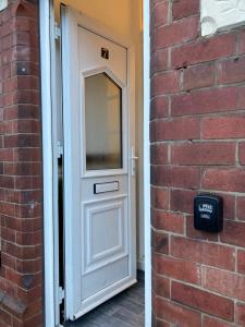 a white door in a brick wall with a window at Central Doncaster 5BED 3BATH ParkView Mansion in Doncaster