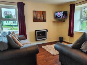 a living room with two couches and a fireplace at Holiday Cottage 6 in Watermillock