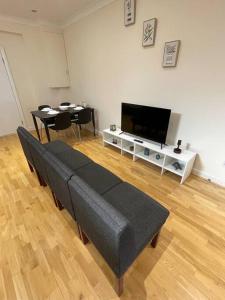 a living room with a couch and a flat screen tv at Whole Flat Close To Wembley in Wealdstone